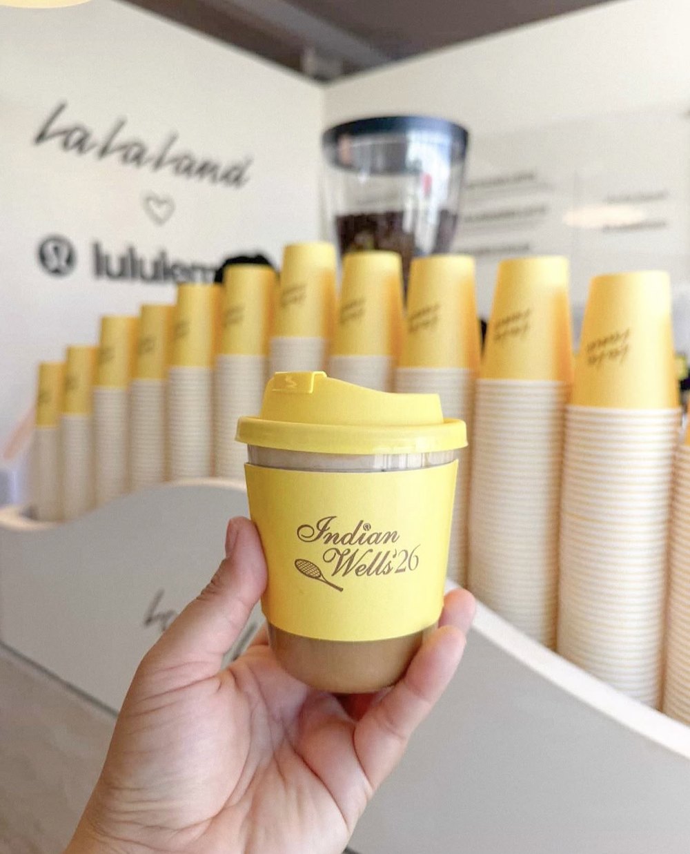 Custom-branded yellow coffee cups at a Los Angeles brand activation